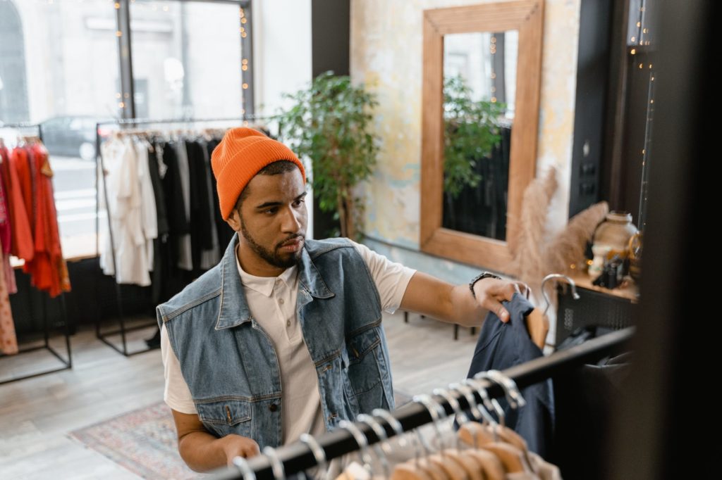 Homem comprando roupas em loja comercial