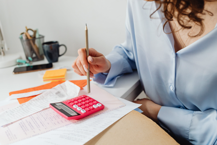 Mulher fazendo conta na calculadora