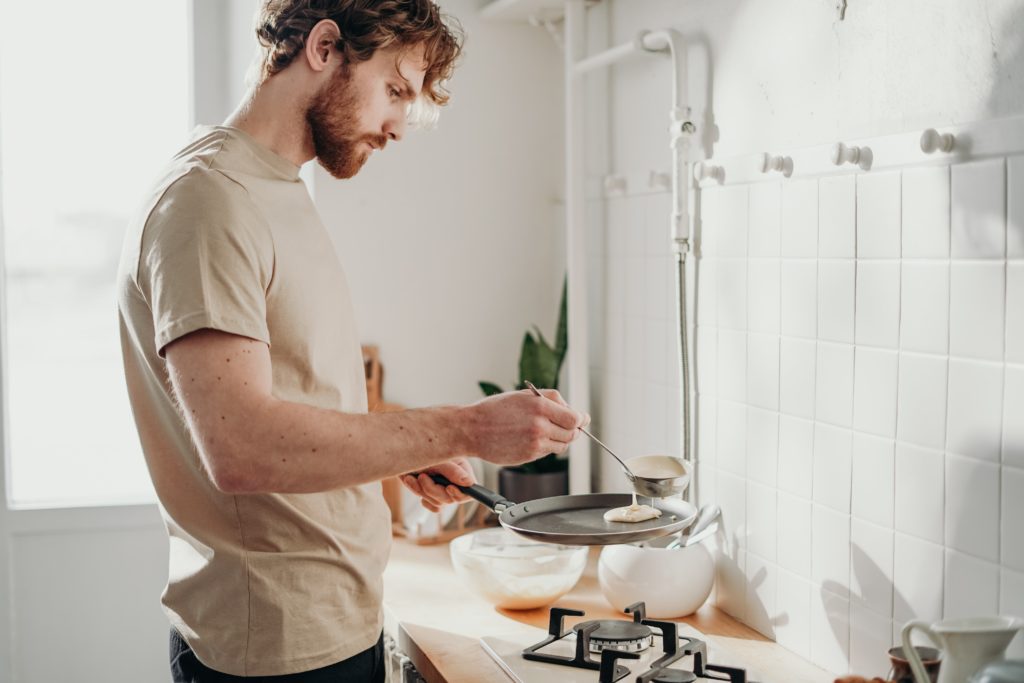 Homem cozinhando em fogão cooktop