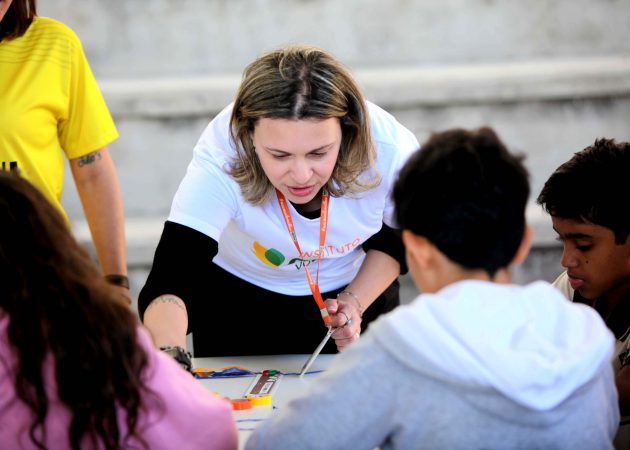 Voluntária do Instituto MRV pintando com crianças