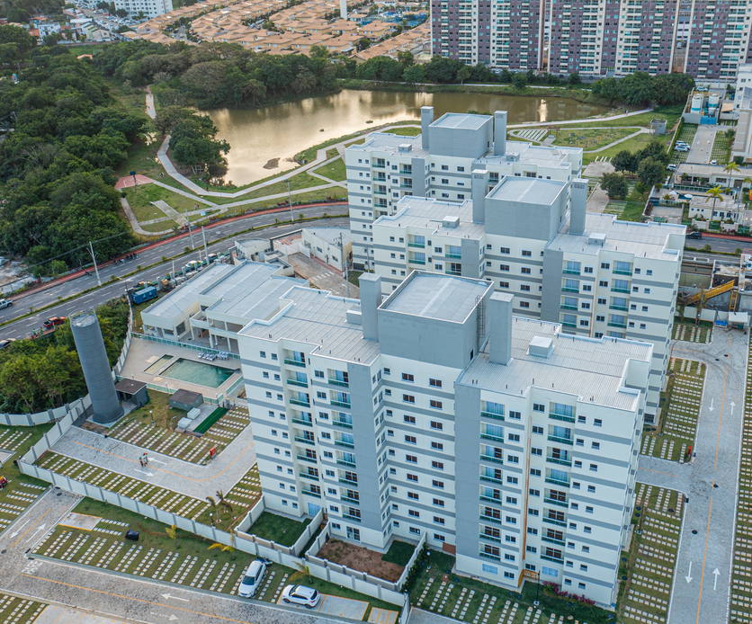 A imagem mostra o condomínio Luggo Vilas Parque com uma área verde ao fundo para ilustrar a importância de escolher um imóvel com boa localização antes de sair de casa para morar sozinho