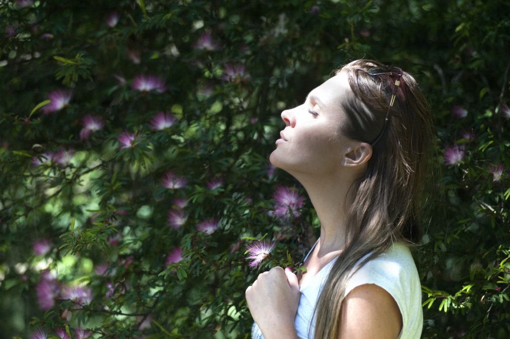 Mulher aproveitando o ar leve de um jardim