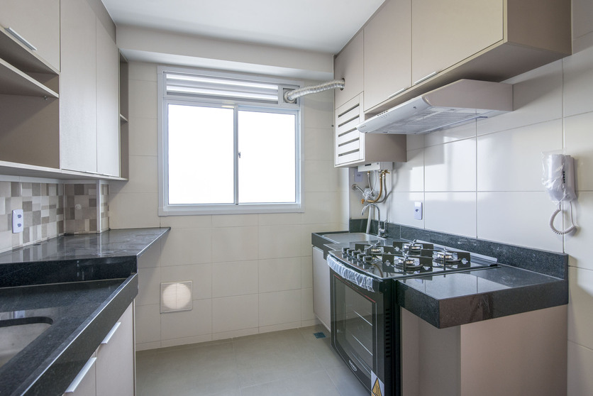 A imagem mostra uma cozinha com armários planejados, com fogão e coifa instalados