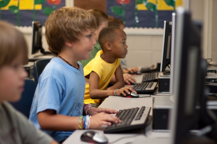 criançs em uma sala de informática para ilustrar a educação que vem do IPTU