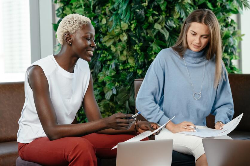 Duas pessoas em uma sala avaliando empreendimentos a partir da nota NPS