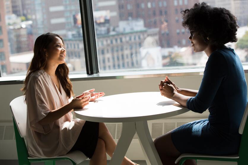 Duas pessoas conversando em uma mesa para ilustrar o atendimento e a nota NPS