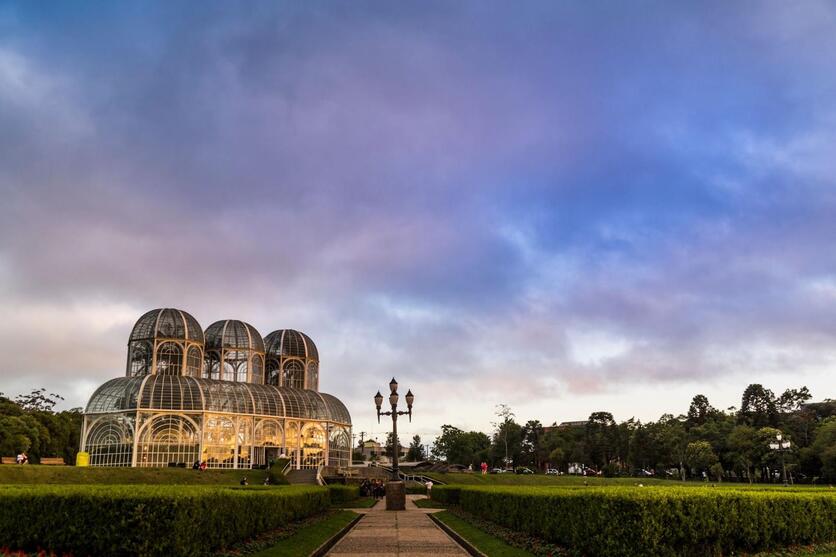 Jardim Botânico de Curitiba com o céu escurecendo ao fundo.