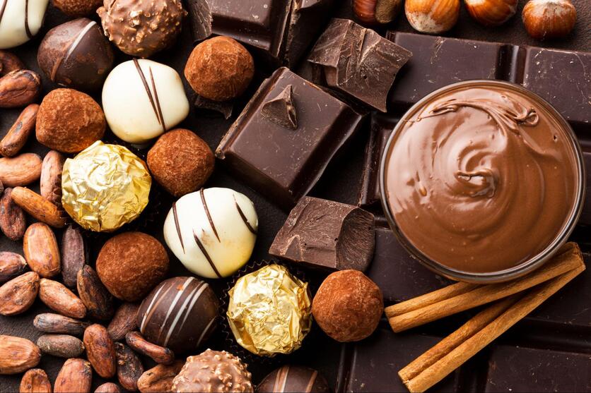 Diversos tipos de chocolates alinhados em cima de uma mesa.