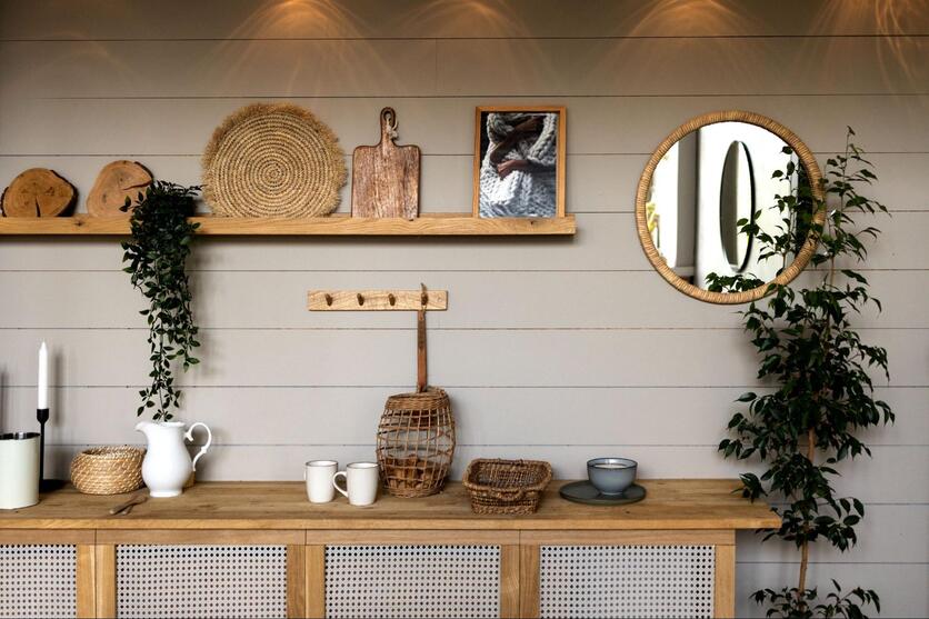 Bancada de cozinha com decoração rústica, incluindo móveis amadeirados, plantas e utensílios de materiais naturais.