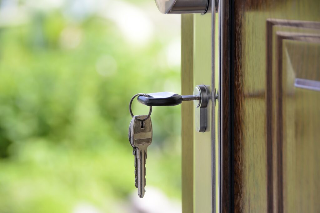 Chave pendurada em uma porta representando um apartamento alugado com um contrato de aluguel com a parte da rescisão bem estabelecida. 