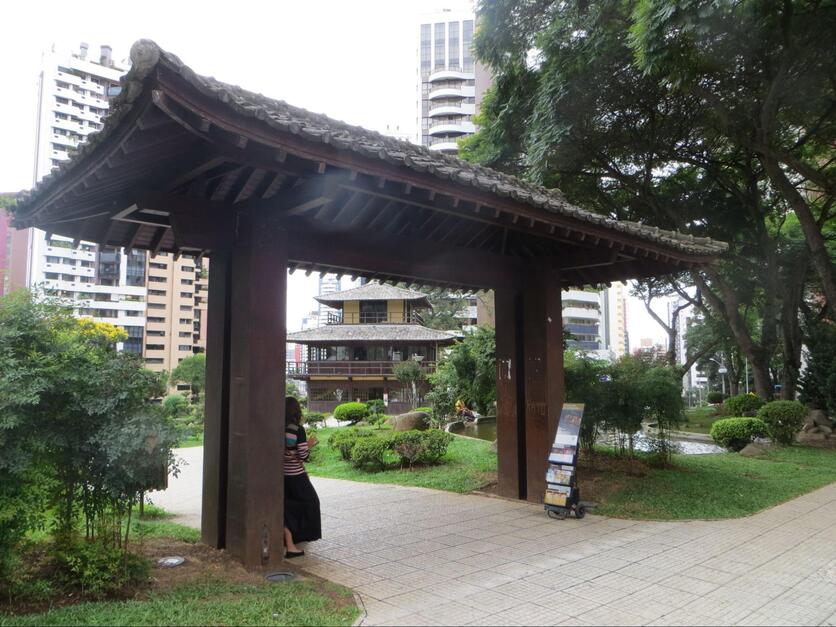 Entrada da Praça do Japão, no bairro Batel em Curitiba, durante o dia, com portão tradicional japonês.